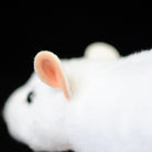 Close-up of the white lab mouse plush toy’s ear, showing detailed craftsmanship and soft texture