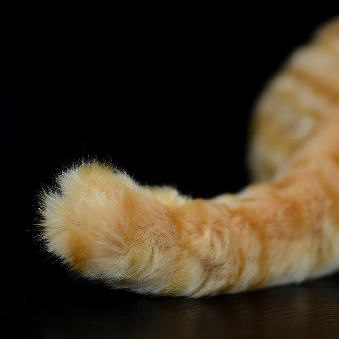Detailed view of the orange tabby plush toy's fluffy tail, perfect for cuddling or decoration