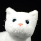 Close-up of the white cat plush toy's face, featuring lifelike blue eyes and a soft pink nose