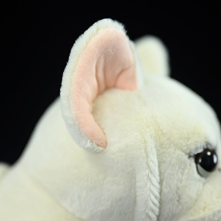Close-up of the cream French Bulldog plush toy's ear, showing its realistic texture and soft pink inner detail