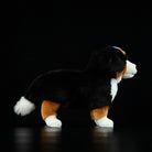 Side profile of a Bernese Mountain Dog plush toy, highlighting its realistic design and adorable build