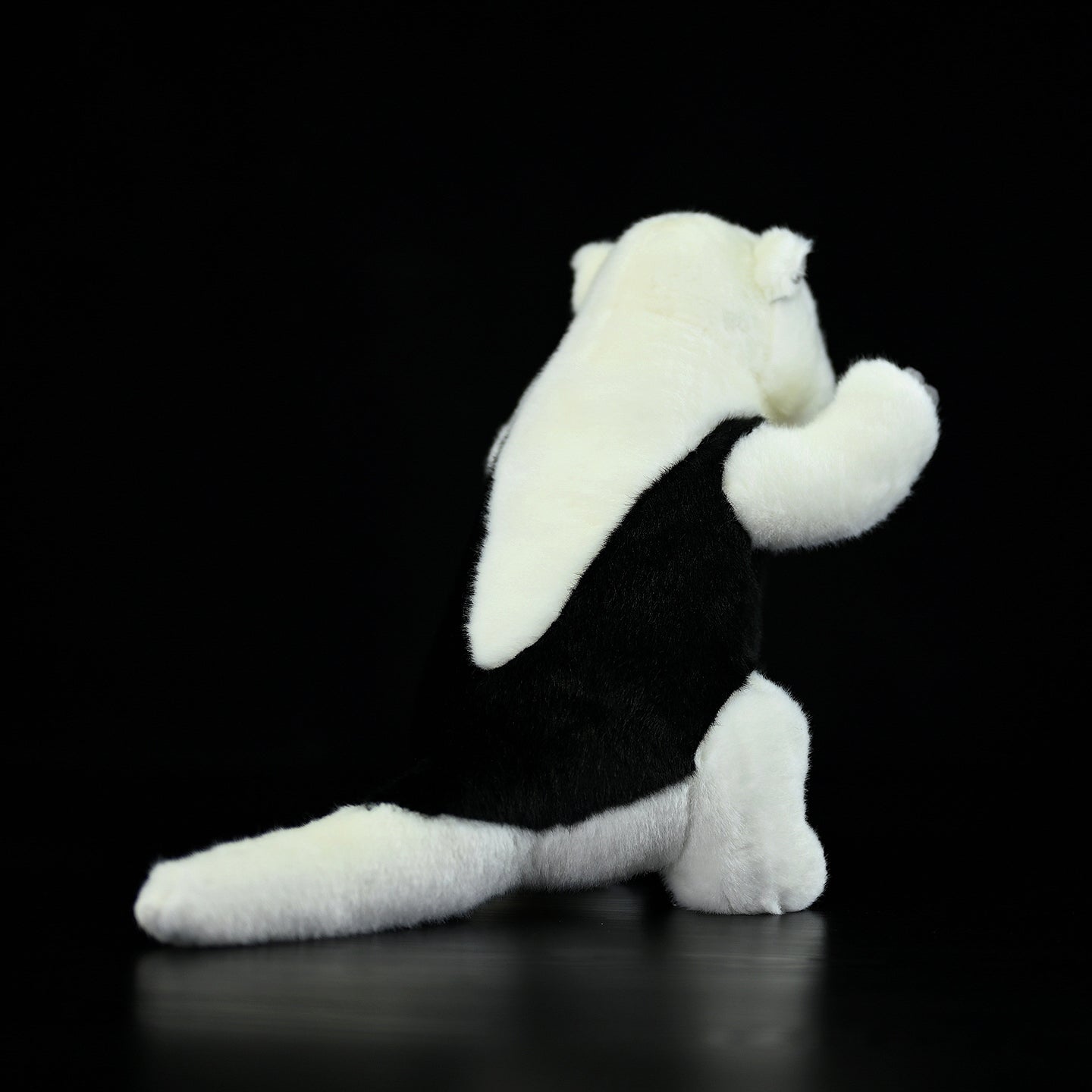 Rear view of a Southern Tamandua stuffed animal, showing its detailed back and fluffy tail