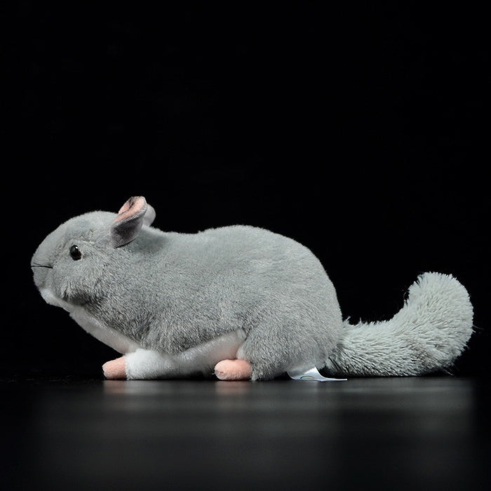 Side profile of a lifelike chinchilla plush toy, featuring its fluffy tail and soft gray fur