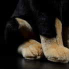 Close-up of the adorable Doberman plush toy's paws, showcasing soft and realistic craftsmanship