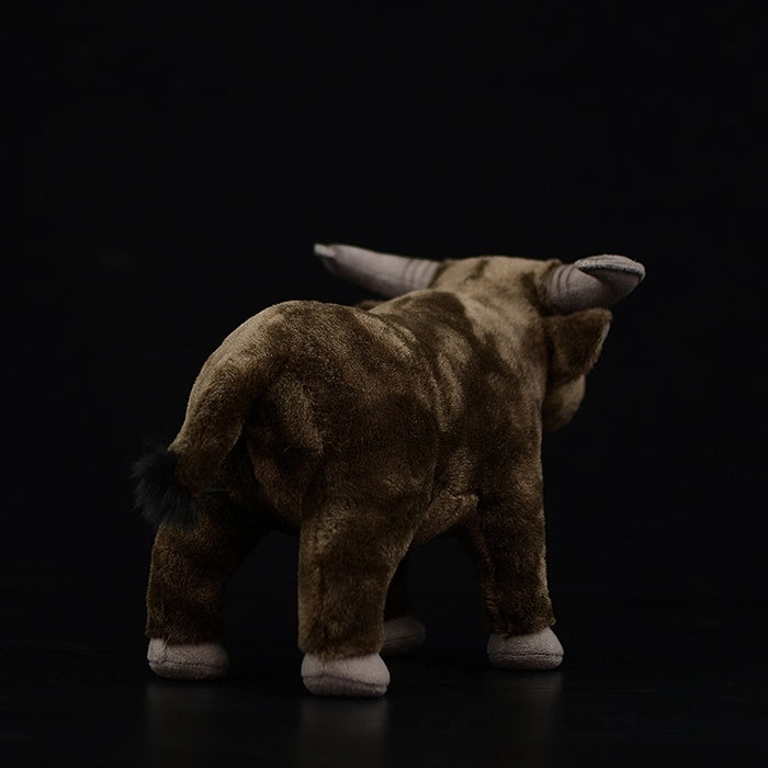 Rear view of a detailed water buffalo plush toy, highlighting its lifelike tail and soft fur design