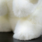 Close-up of the rabbit plush toy's soft paws, showcasing realistic fur details and cuddly texture