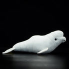 Side profile of a beluga whale stuffed animal, featuring realistic design and soft texture