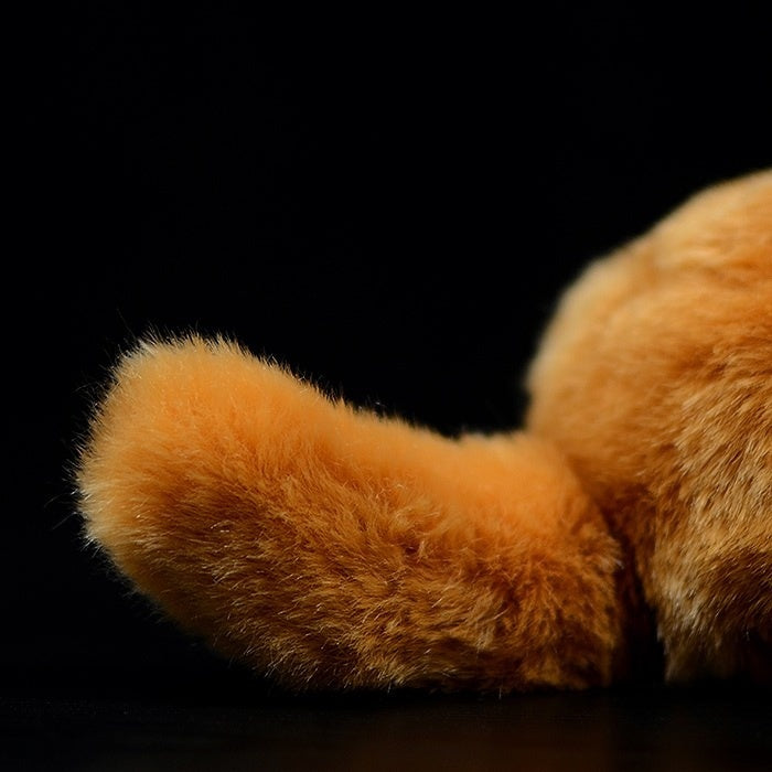 Detailed view of the fluffy orange tail of the Orange Tuxedo Cat plush toy