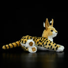 Side view of a serval cat plush toy with realistic spotted fur, soft texture, and lifelike details