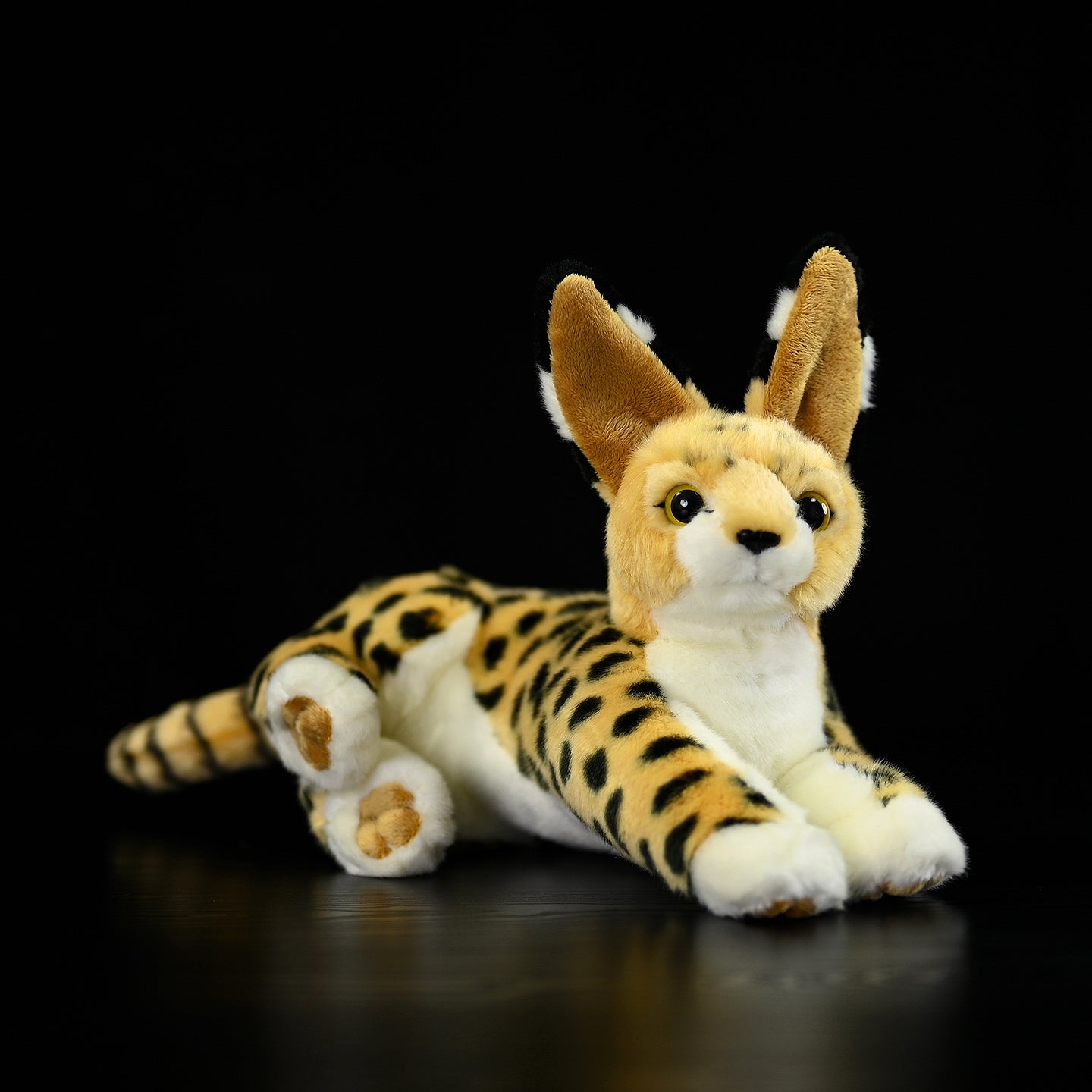 Lifelike Serval cat plush toy lying down, showcasing its adorable face and realistic design