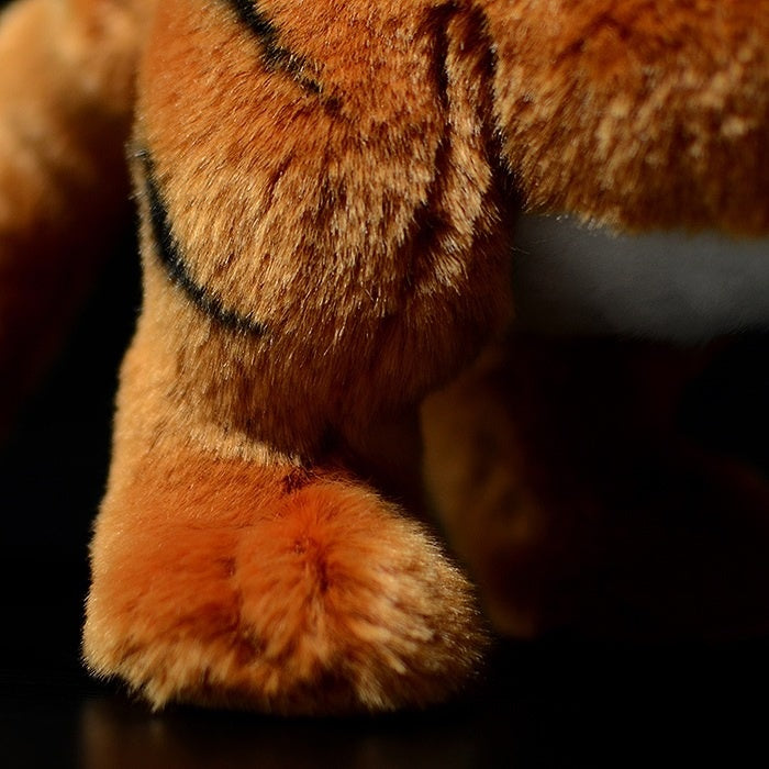 Detailed shot of a tiger cub plush toy's paw, featuring soft fur and realistic textures