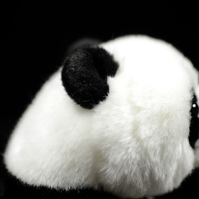 Close-up of a giant panda plush toy's ear, highlighting its soft and realistic texture