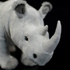 Close-up of the realistic white rhino plush toy's horn and face, designed for lifelike appeal