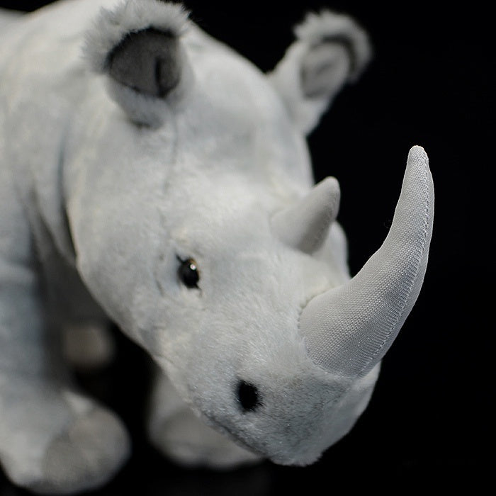 Close-up of the realistic white rhino plush toy's horn and face, designed for lifelike appeal