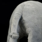 Rear close-up of a white rhinoceros stuffed animal, highlighting its realistic tail