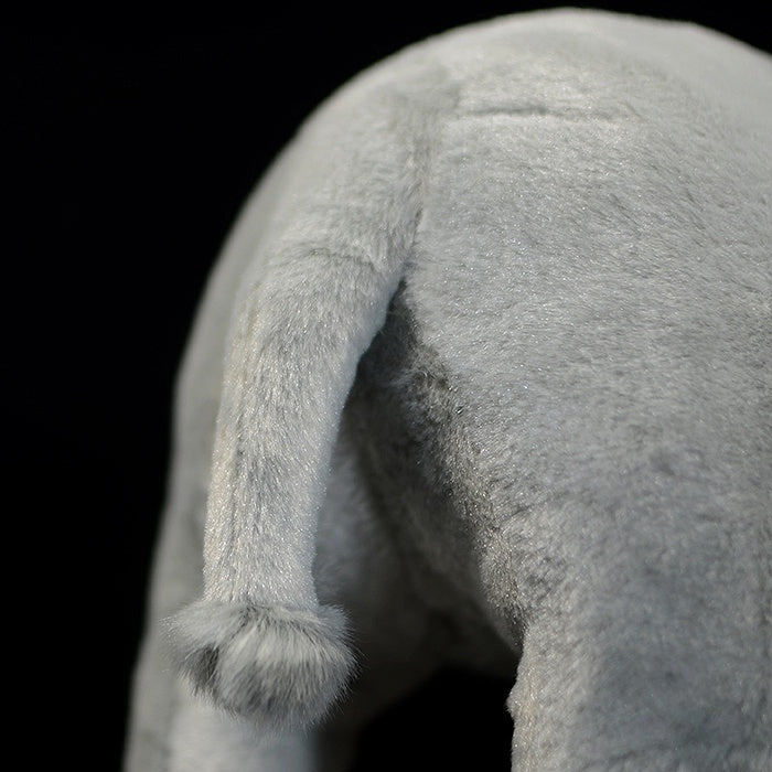 Rear close-up of a white rhinoceros stuffed animal, highlighting its realistic tail