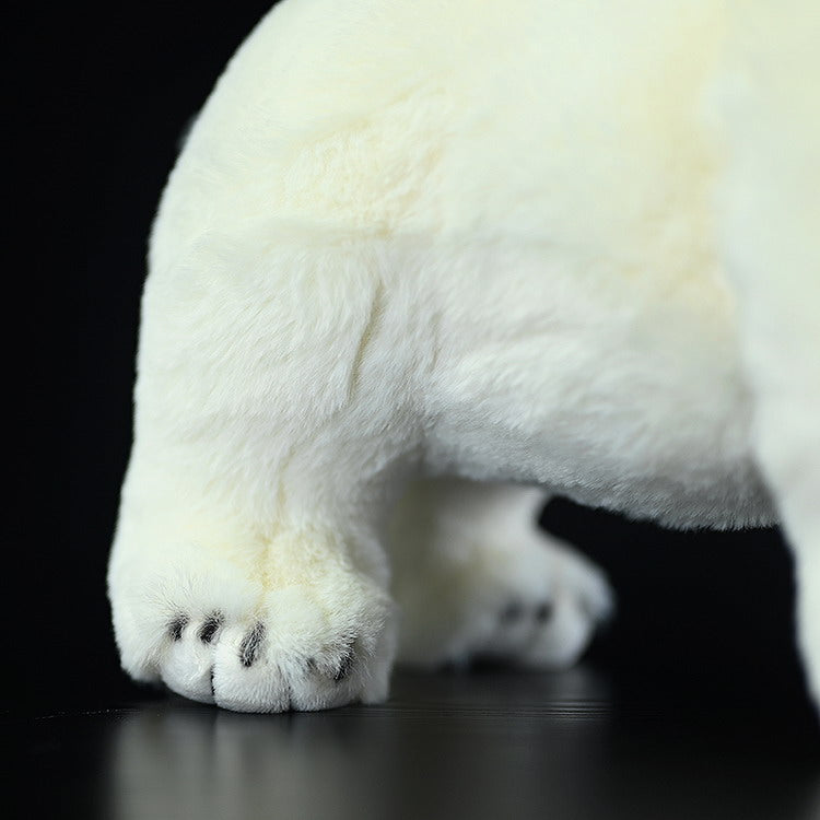 Close-up of the polar bear plush toy's paws, featuring realistic details and soft, cuddly fabric