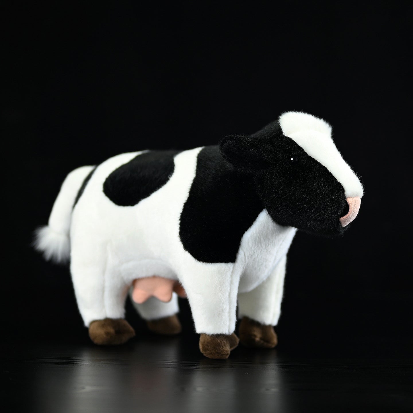 Realistic plush Holstein cow toy with black-and-white markings, perfect for animal lovers and collectors