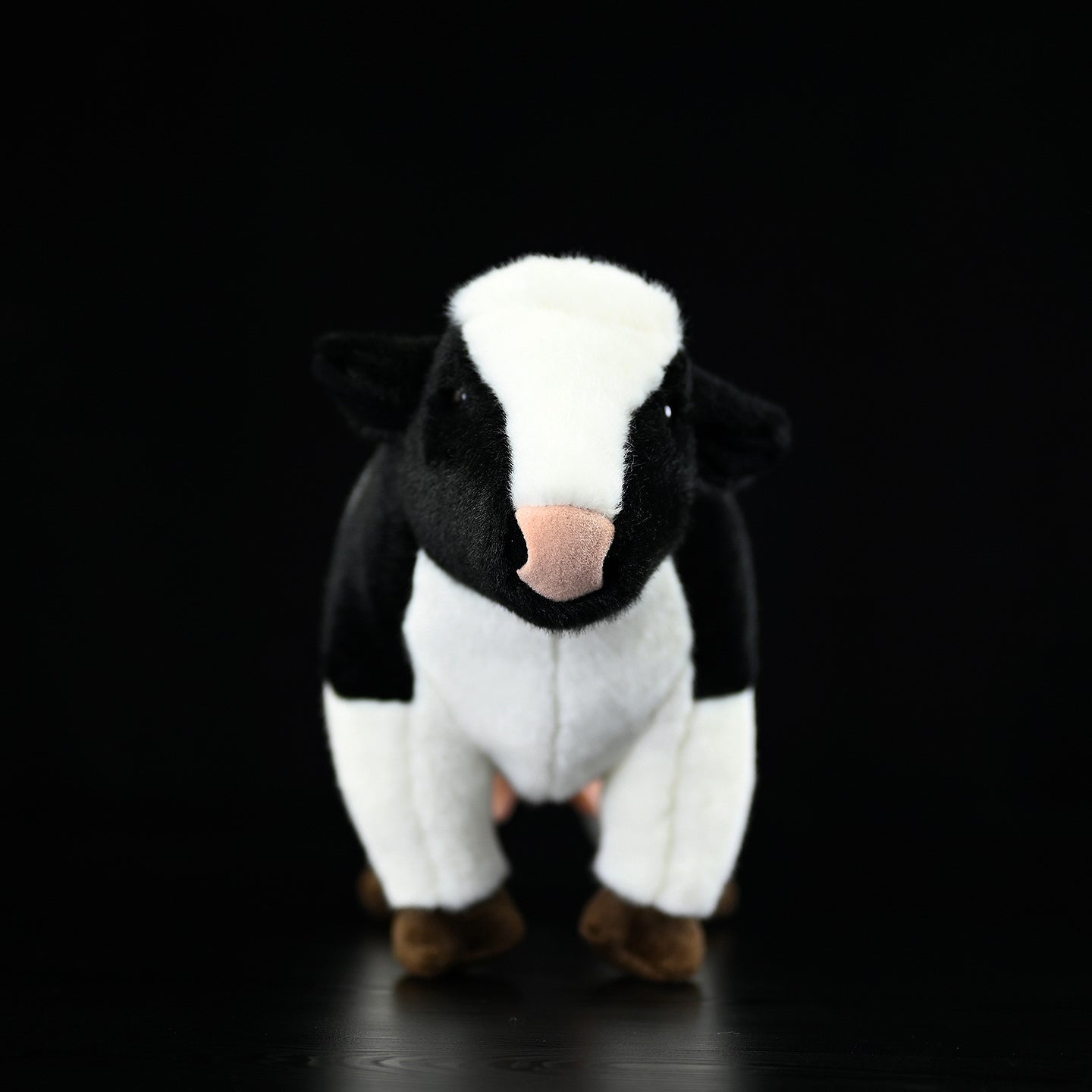 Front view of a soft Holstein cow plush featuring a lifelike black-and-white design and detail