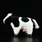 Side profile of a lifelike Holstein cow plush toy with realistic markings and adorable details