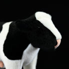Detailed close-up of a plush Holstein cow’s head, with soft fabric and realistic black-and-white features