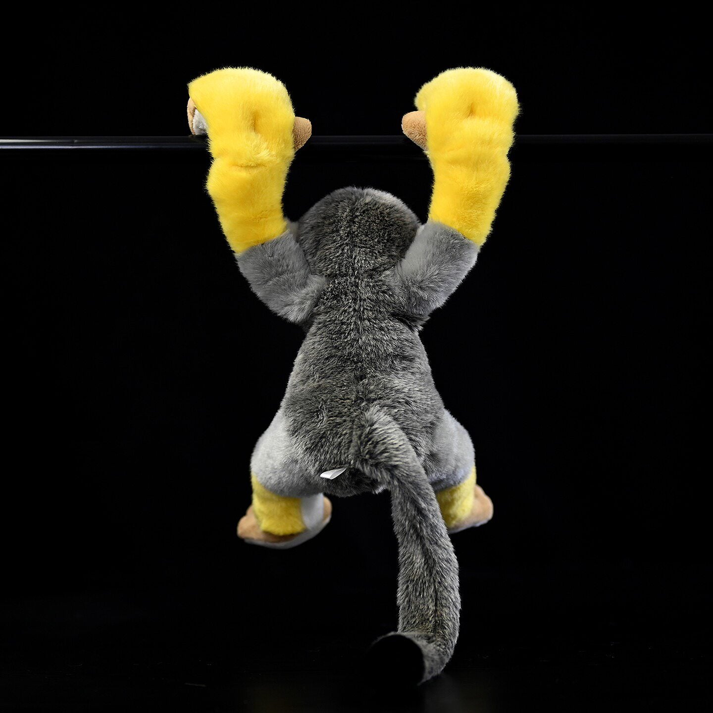 Back view of Common Squirrel Monkey plush hanging, showcasing realistic design and soft fur