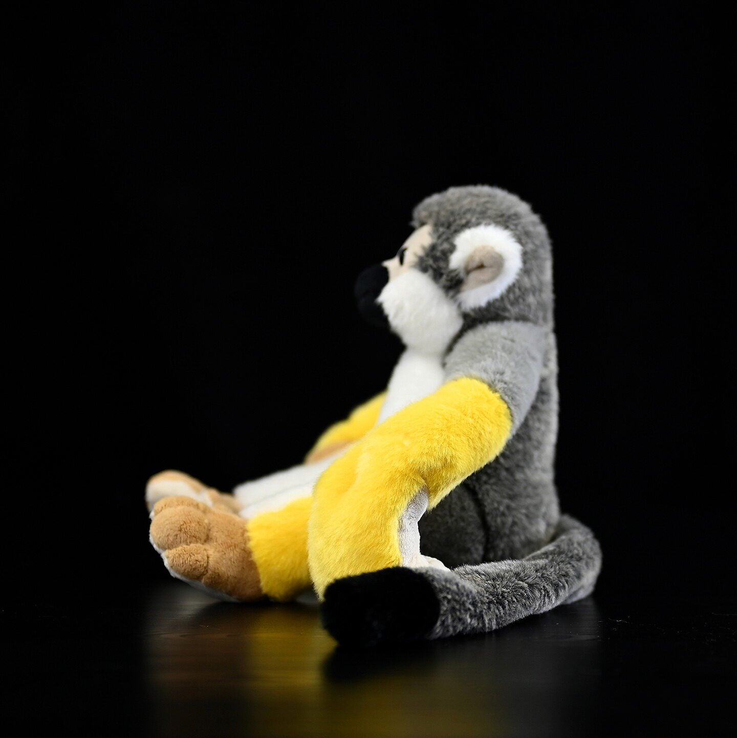 Side view of Common Squirrel Monkey plush featuring soft fur and realistic poseable arms
