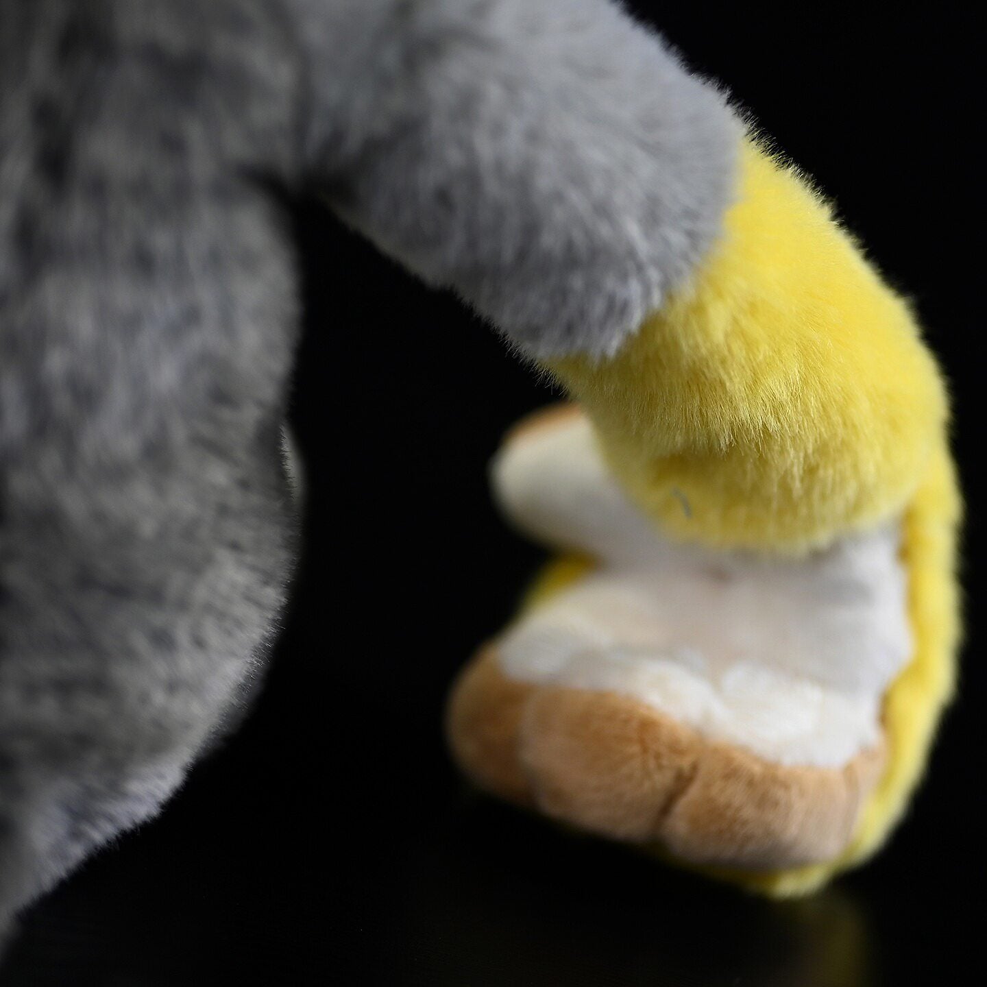 Hand detail of Common Squirrel Monkey plush, showing accurate design and soft yellow fur