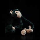 Side view of a sitting chimpanzee plush with soft fur and realistic features, a charming stuffed animal toy