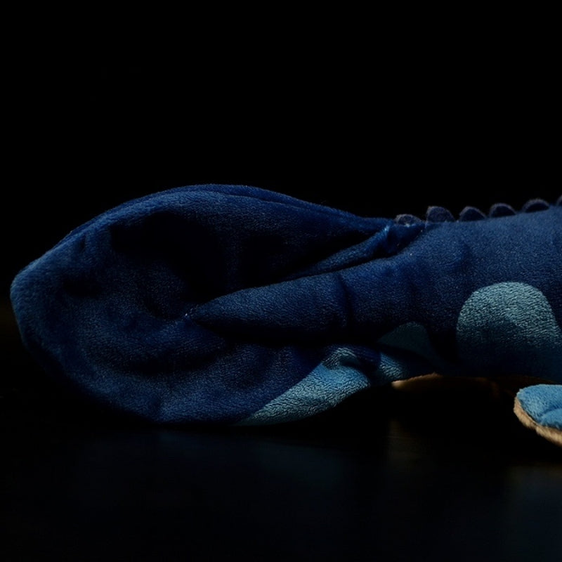 Close-up of Mosasaurus stuffed toy’s paddle-shaped tail with smooth texture and ocean-themed colors