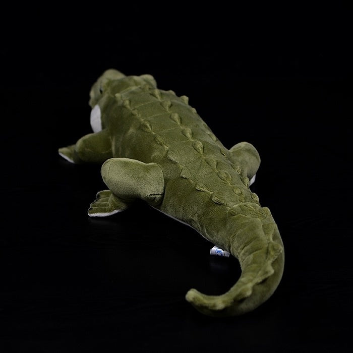 Back view of a realistic alligator plush, highlighting its textured tail and lifelike appearance
