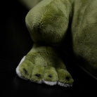 Close-up of the alligator plush’s foot, highlighting its soft green fabric and detailed design