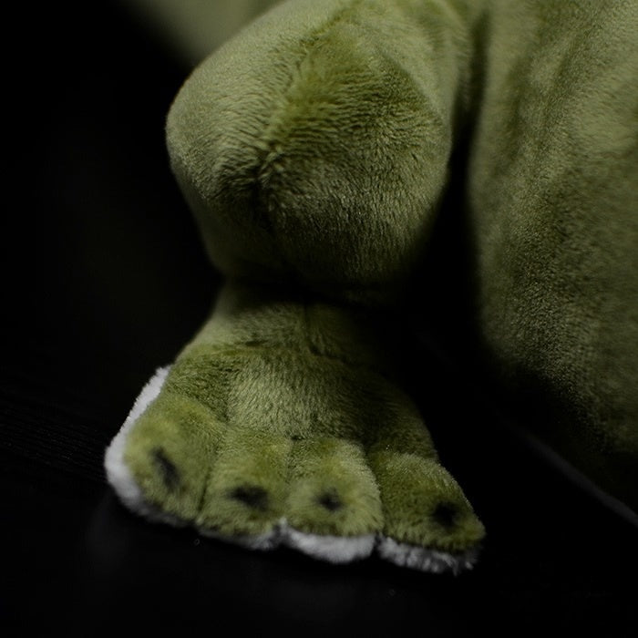 Close-up of the alligator plush’s foot, highlighting its soft green fabric and detailed design