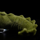 Close-up of the realistic alligator plush's tail, showing soft fabric and detailed texture