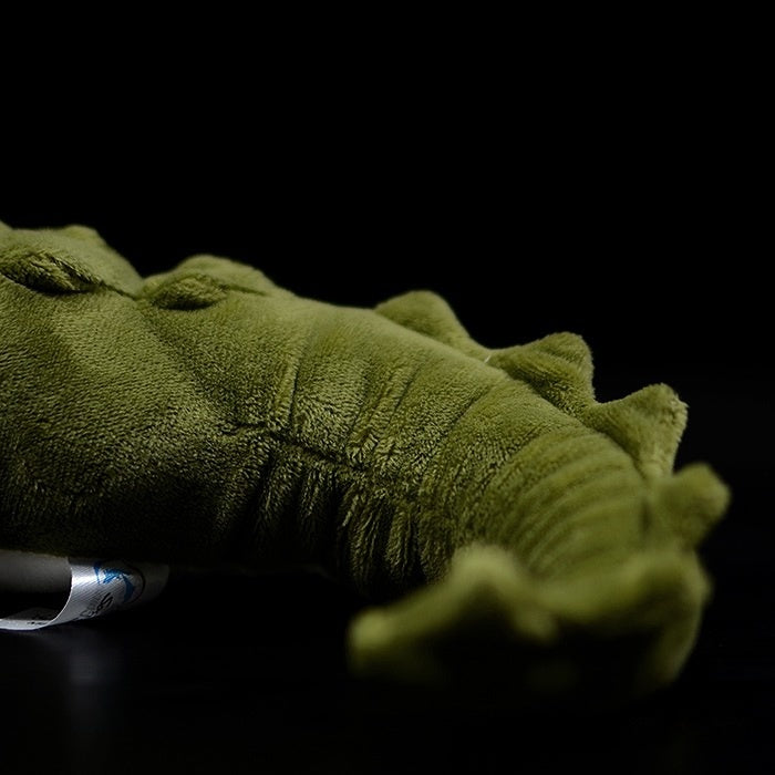 Close-up of the realistic alligator plush's tail, showing soft fabric and detailed texture