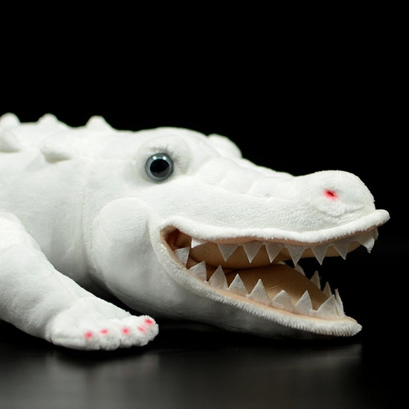 Close-up of albino alligator plush toy's smiling face and sharp teeth detail
