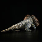 Back view of a frilled lizard plush, highlighting its textured tail and lifelike frill design