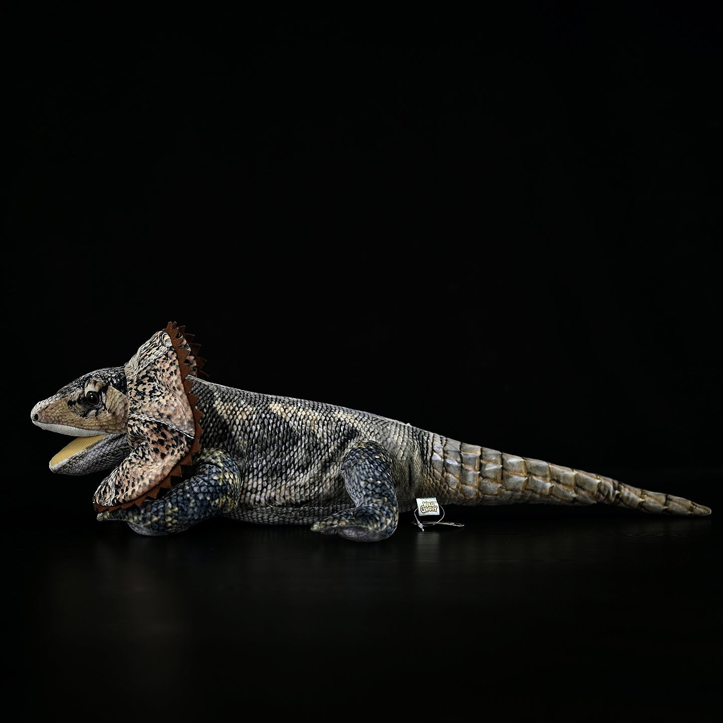 Side view of a frilled lizard plush, showcasing intricate details, realistic scales, and a vibrant frill