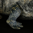 Close-up of a frilled lizard plush leg, highlighting its detailed scales and lifelike craftsmanship