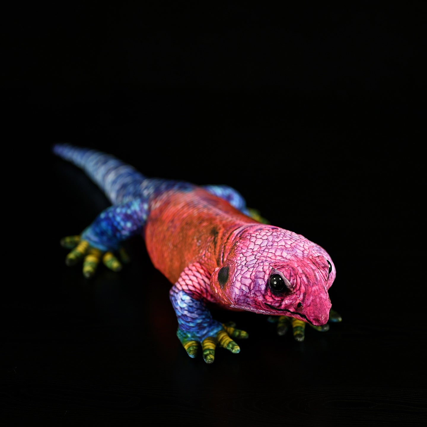 Side angle of a Spider-Man Agama plush showcasing its colorful red, blue, and green tones in lifelike detail