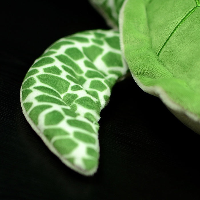 Close-up of the green sea turtle plush's flipper, highlighting its realistic textured pattern