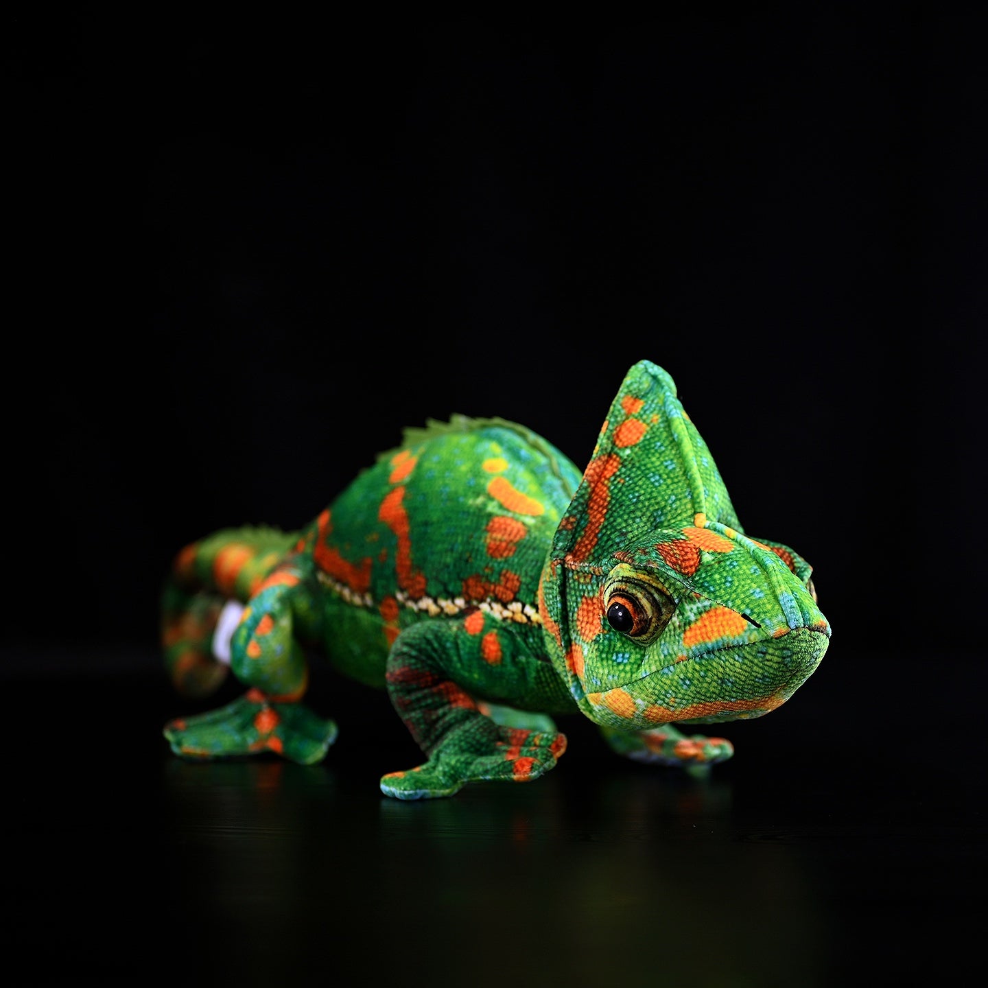 Realistic veiled chameleon plush toy in a crawling pose with vivid green and orange patterns