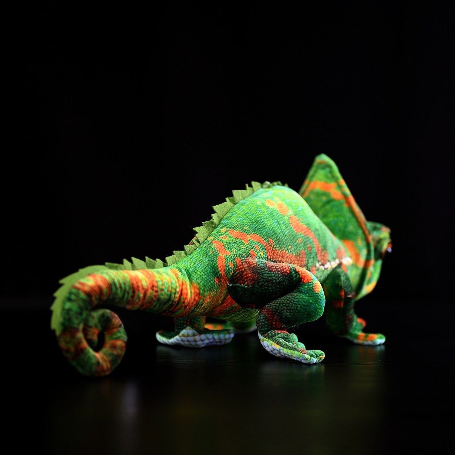 Back view of a veiled chameleon plush toy highlighting its curled tail and detailed scales