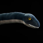 Close-up of SoftDaysLab® plush plesiosaur face with bright yellow eyes and realistic embroidered teeth
